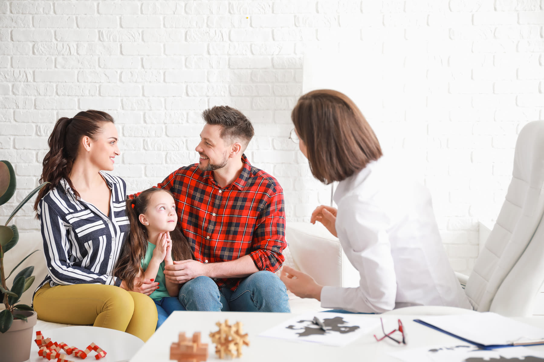 Parents and their young daughter meeting with a therapist