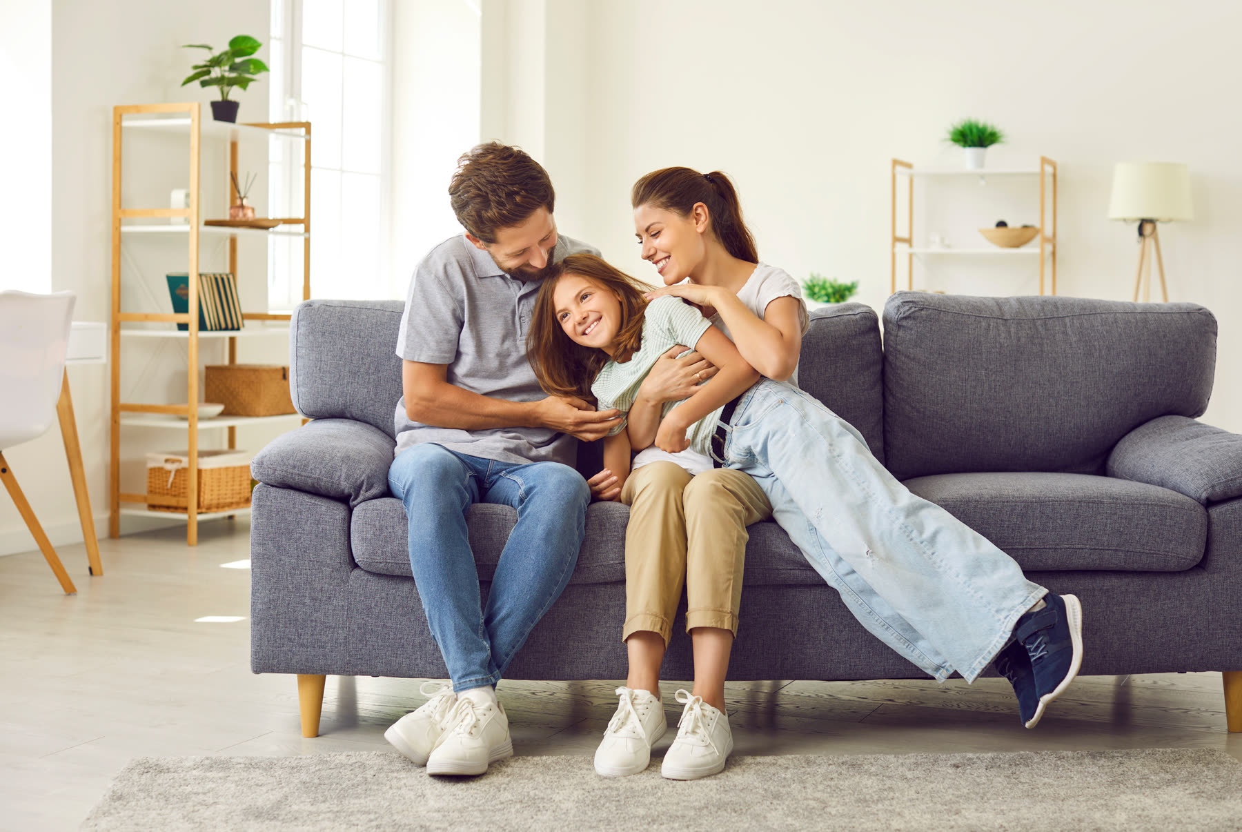 A relaxed family laughing together on the couch at home