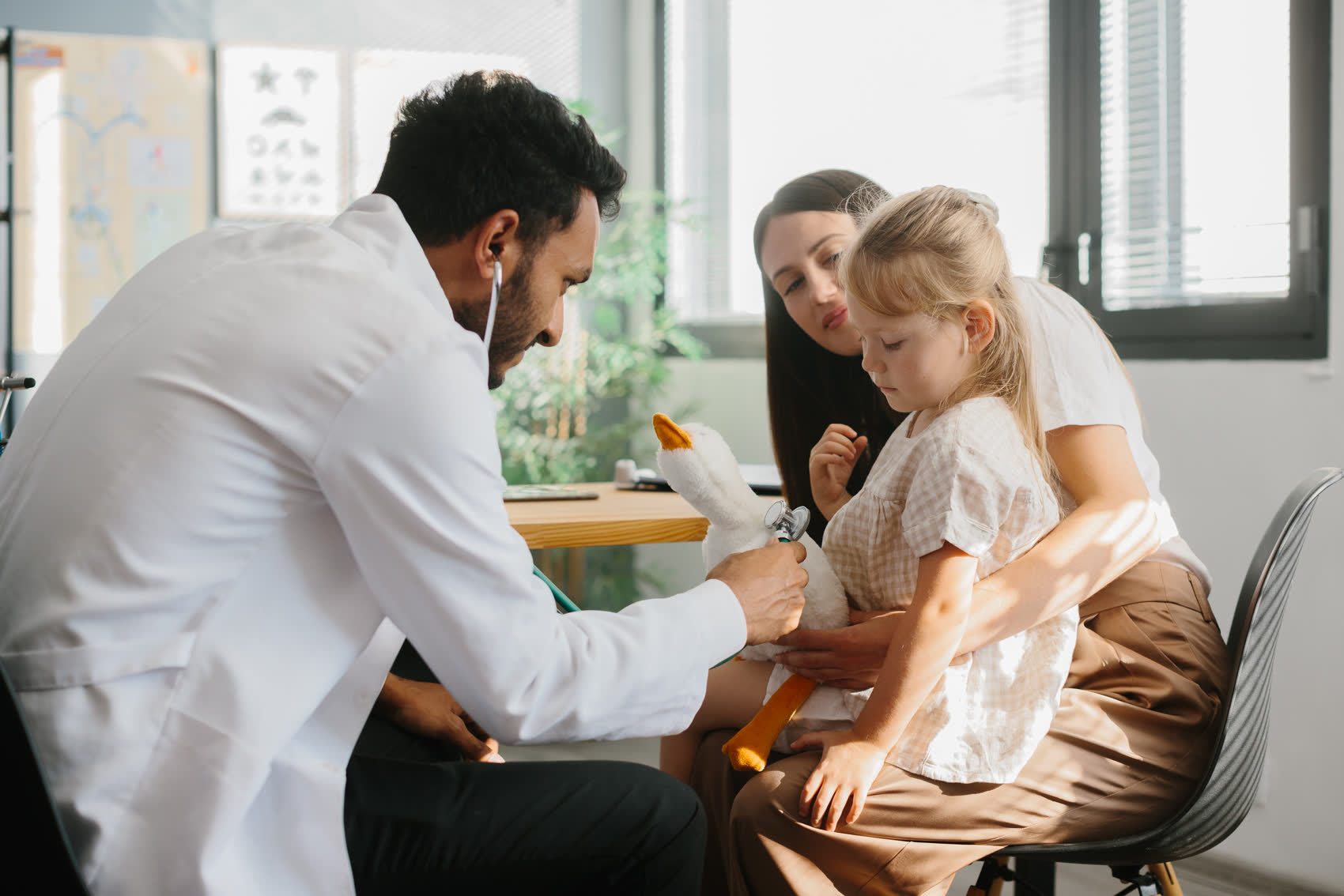 A mother and her daughter talking with a doctor at a clinic