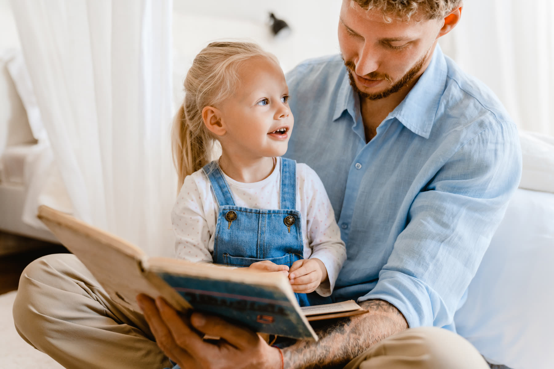 A father reading a picture book with his daughter