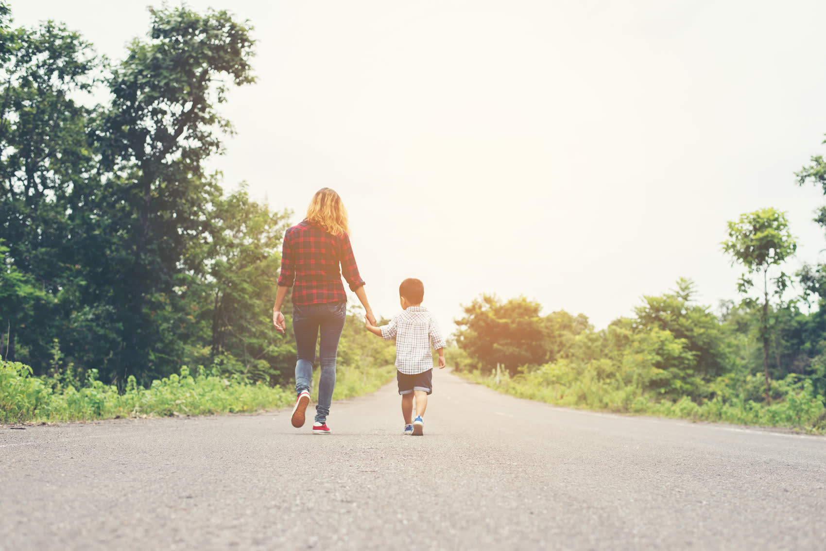 A mother walking hand in hand with her young son